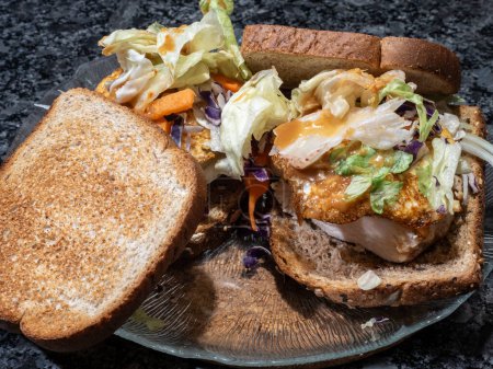 Téléchargez les photos : Sandwich santé avec pain de maïs complet rôti, poulet grillé, œuf frit et salade dans une assiette en verre. - en image libre de droit
