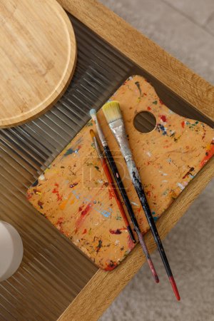 Photo for Palette with paint brushes on wooden table - Royalty Free Image