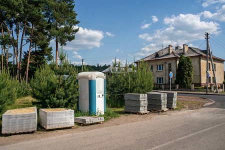 Photo for Portable toilet and building materials on the street. - Royalty Free Image