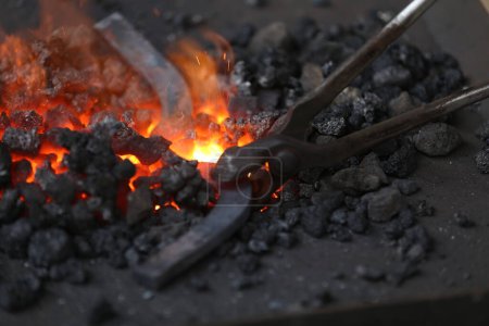 Téléchargez les photos : Forgeage forge forge pour durcir et chauffer le fer. Forgeron travaillant à l'atelier de forge. Smith a fait une vieille chaussure de cheval - en image libre de droit
