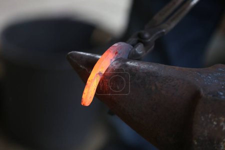 Photo for Smithy forging for hardening and heating iron. Blacksmith working at smithy workshop. Smith made an old fashioned  horse shoe - Royalty Free Image