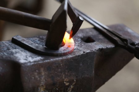 Photo for Smithy forging for hardening and heating iron. Blacksmith working at smithy workshop. Smith made an old fashioned  horse shoe - Royalty Free Image