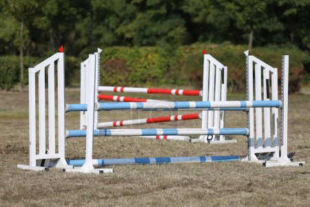 Photo for Show jumping poles obstacles, barriers, waiting for riders on show jumping training. Horse obstacle course outdoors summertime - Royalty Free Image