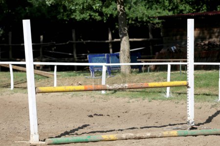 Téléchargez les photos : Pôles de saut d'obstacles, barrières, attente pour les cavaliers sur l'entraînement de saut d'obstacles. Course d'obstacles à cheval en plein air été - en image libre de droit