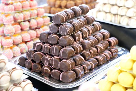 Téléchargez les photos : Bonbons de massepain au chocolat rempli diverses saveurs. Boules de douceur construire comme une pyramide pour la sle dans une pâtisserie - en image libre de droit