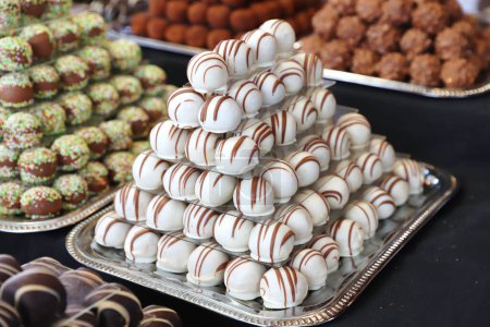 Los caramelos de mazapán de chocolate llenaron varios sabores. Bolas de dulzura construidas como una pirámide para sle en una pastelería