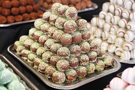 Foto de Los caramelos de mazapán de chocolate llenaron varios sabores. Bolas de dulzura construidas como una pirámide para sle en una pastelería - Imagen libre de derechos