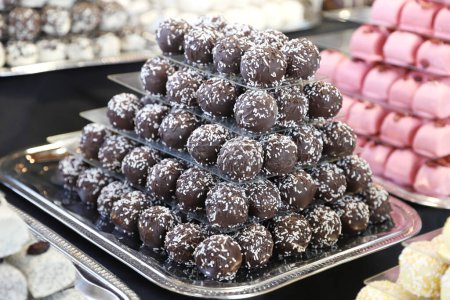 Téléchargez les photos : Bonbons de massepain au chocolat rempli diverses saveurs. Boules de douceur construire comme une pyramide pour la sle dans une pâtisserie - en image libre de droit