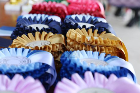 Photo for Group of beautiful colorful trophies and ribbons for the winners and participants at open air equestrian racehorse event - Royalty Free Image