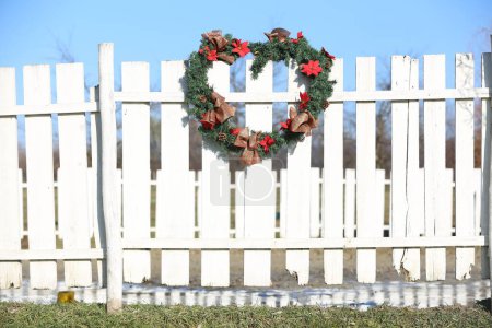 Belle couronne de Noël accrochée à la clôture du corral à la ferme animale rurale Noël. Magnifique décor de Noël fait à la main 