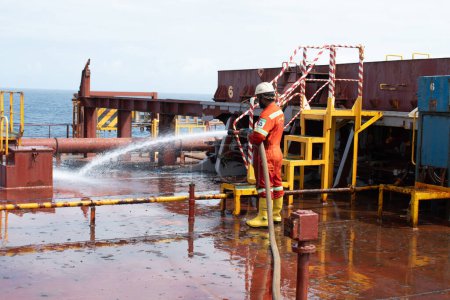 Photo for At sea - october 16, 2023 : ship's crew hosing down at cross deck of a cape size bulk carrier for deck cleaning purpose - Royalty Free Image