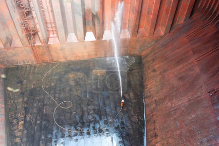Photo for At sea - october 15, 2023 : hosing down inside cargo hold of a bulk carrier for hold cleaning - Royalty Free Image