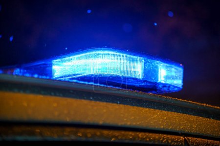 Téléchargez les photos : Blue lights of a police car with raindrops during a night - en image libre de droit