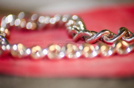 Foto de Golden chain on a red cloth that looks blurry - Imagen libre de derechos