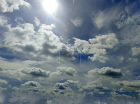 Foto de Nubes blancas y grises y los rayos del sol del mediodía contra un cielo claro - Imagen libre de derechos