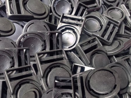 Foto de Pila de botones de gancho de plástico negro. un conjunto de ganchos o botones de tarjetas de identificación negras. tapón de plástico industrial - Imagen libre de derechos