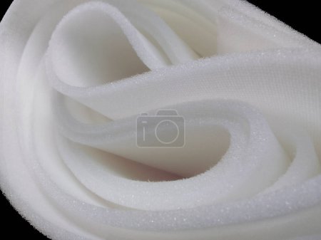 Téléchargez les photos : Un rouleau de mousse éponge blanche sur fond noir - en image libre de droit