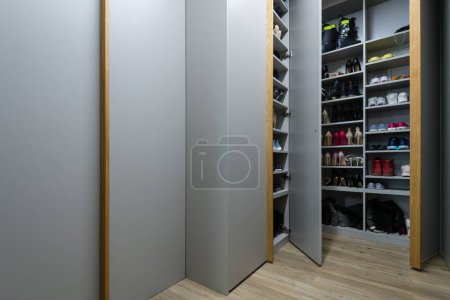 Photo for Giant gray closet full of shoes on hallway of modern apartment - Royalty Free Image
