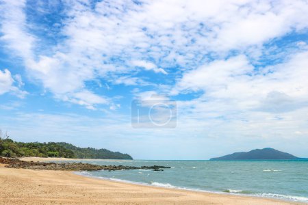 Foto de Playa rocosa arenosa tropical con aguas claras y azules bajo un cielo azul con nubes de cirros. - Imagen libre de derechos