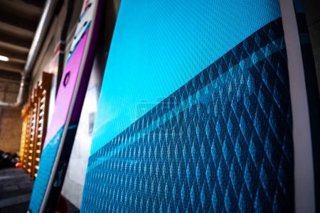 Foto de Tableros de paddle stand-up azul y rosa SUP junto a la pared. Surf y sup equipo de abordaje de cerca. - Imagen libre de derechos