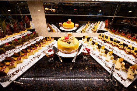 Photo for Variety of sweets including cakes, eclairs and Turkish sweets, arranged beautifully on a table in a luxury all-inclusive hotel. perfect for use in food, travel and luxury related designs - Royalty Free Image