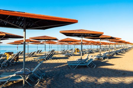 Téléchargez les photos : Transats et parasols sur la plage de sable fin dans la station touristique de luxe - en image libre de droit