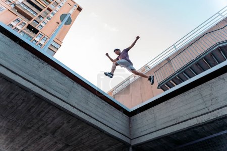 Photo for Talented young man practicing parkour tricks in the city and having fun. - Royalty Free Image