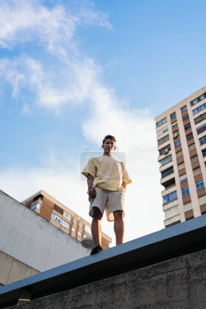 Photo for Confident young man wearing casual clothes posing and looking at camera in the city. - Royalty Free Image
