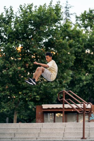 Photo for Confident young man practicing parkour in the park and having fun. - Royalty Free Image