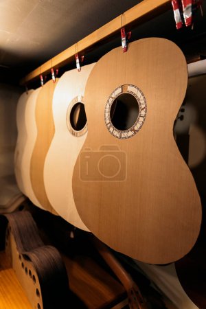 Téléchargez les photos : Silhouette de guitares acoustiques fabriquées dans un atelier traditionnel. - en image libre de droit