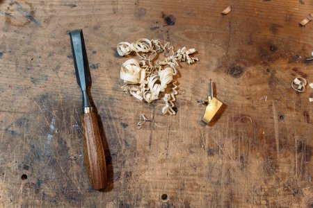 Foto de Primer plano de la herramienta utilizada en el taller tradicional y astillas de madera. - Imagen libre de derechos
