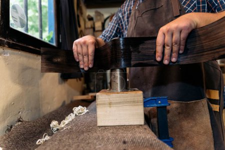 Téléchargez les photos : Luthier méconnu créant une guitare dans son atelier et utilisant des outils. - en image libre de droit