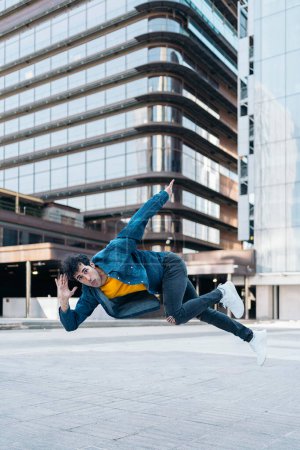 Téléchargez les photos : Cool break danseuse pratiquant dans la rue et s'amusant. Il danse et regarde la caméra. - en image libre de droit