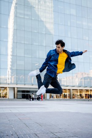 Téléchargez les photos : Jeune homme talentueux dansant dans la rue et pratiquant la break dance. - en image libre de droit