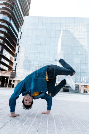Téléchargez les photos : Cool break danseuse pratiquant dans la rue et s'amusant. Il danse et regarde la caméra. - en image libre de droit