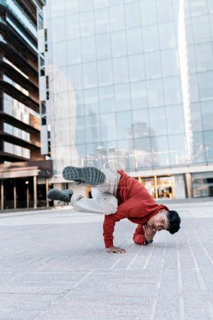 Photo for Cool break dancer practicing in the street and having fun. He is dancing and looking at camera. - Royalty Free Image