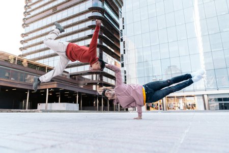 Photo for Talented young boys doing break dance in the street and having fun. They are doing coordinated moves. - Royalty Free Image
