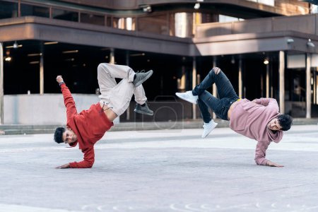 Téléchargez les photos : Des jeunes garçons talentueux qui dansent dans la rue et s'amusent. Ils font des mouvements coordonnés. - en image libre de droit