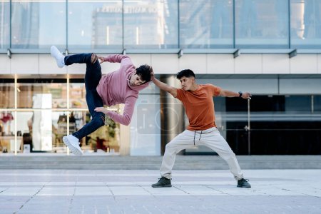Foto de Talentosos jóvenes haciendo break dance en la calle y divirtiéndose. - Imagen libre de derechos