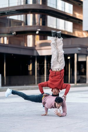 Téléchargez les photos : Incroyables jeunes hommes dansant break dance ensemble dans la ville et s'amusant. - en image libre de droit