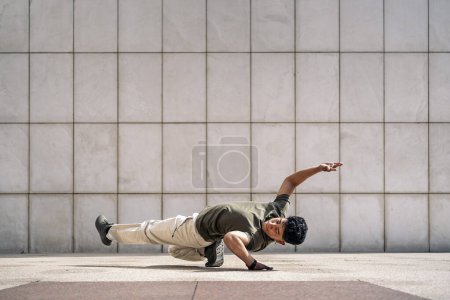 Photo for Cool young latin man doing break dance moves in the street and showing his talent. - Royalty Free Image