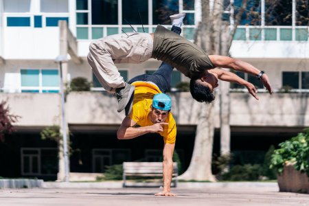 Photo for Two multi-ethnic friends dancing in the park and doing break dance moves. - Royalty Free Image