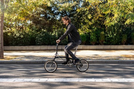 Photo for Stock photo of handsome man using his detachable bike during sunny day. - Royalty Free Image