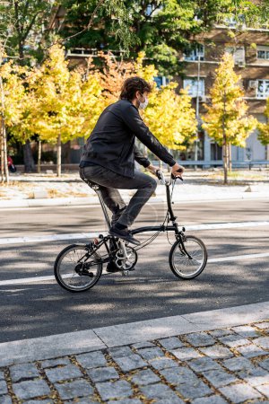 Téléchargez les photos : Stock photo of handsome man using his detachable bike during sunny day. - en image libre de droit