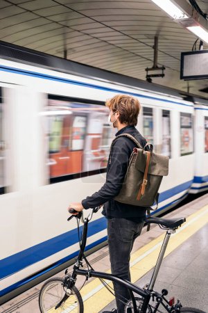 Téléchargez les photos : Photo du jeune homme dans le métro tenant son vélo détachable. - en image libre de droit