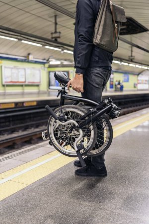 Téléchargez les photos : Photo d'un homme méconnu dans le métro tenant son vélo détachable. - en image libre de droit
