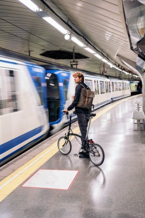 Foto de Stock photo of young man in the metro holding his detachable bike. - Imagen libre de derechos