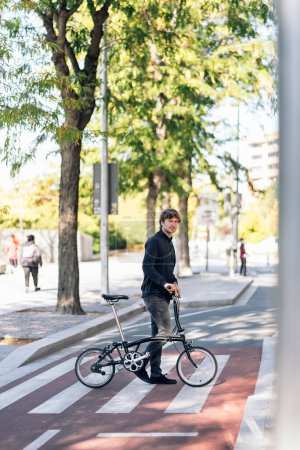 Téléchargez les photos : Stock photo of handsome man using his detachable bike in the street. - en image libre de droit