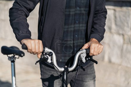 Téléchargez les photos : Stock photo of faceless man walking in the street next to his removable bike. - en image libre de droit