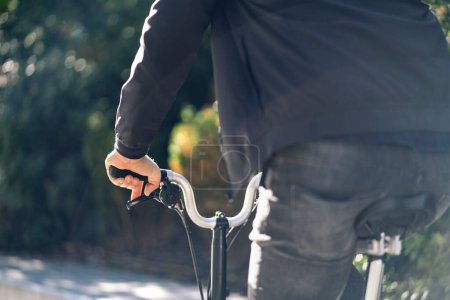 Photo for Stock photo of faceless man walking in the street next to his removable bike. - Royalty Free Image